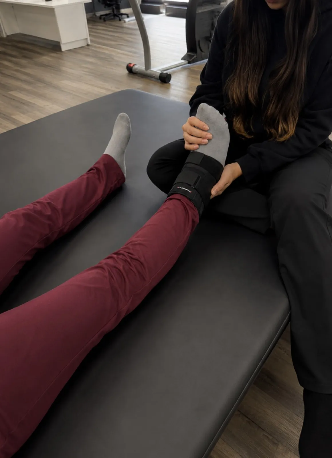 A therapist working on a patient's ankle